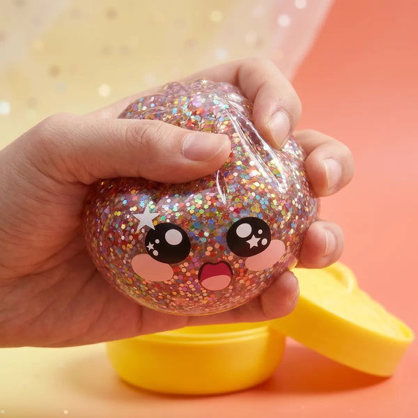 Hands playing with the pink galaxy dumpling squishy stress toy