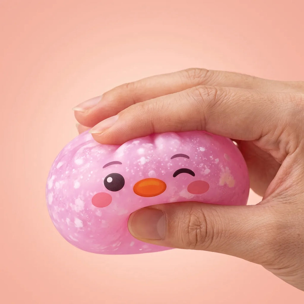 Hand squeezing the pink penguin dumpling squishy to show its slow rise