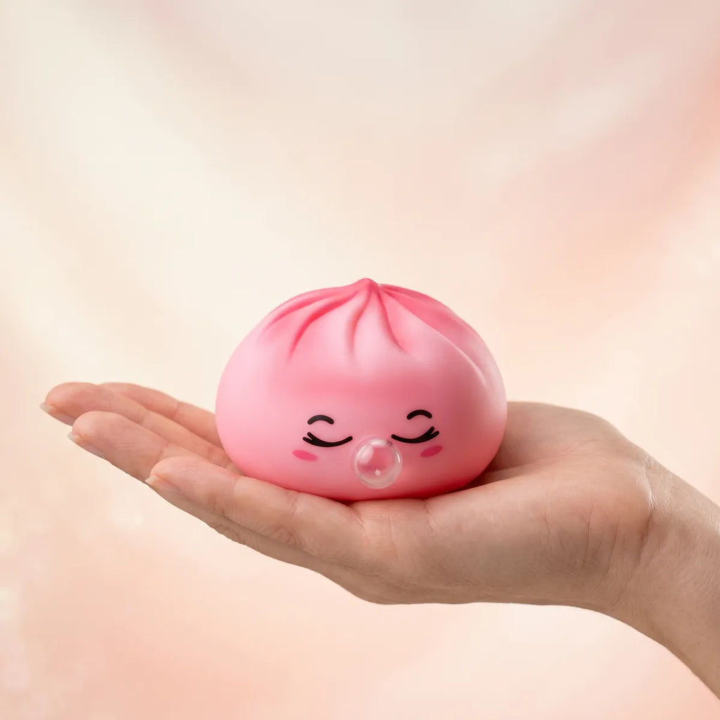 Hand holding a soft pink rare blow dumpling squishy