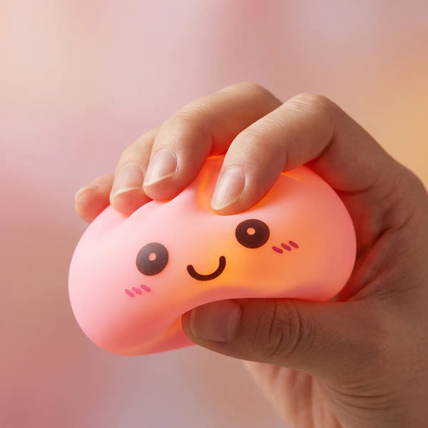 Hands playing with the pink squishy dumpling light