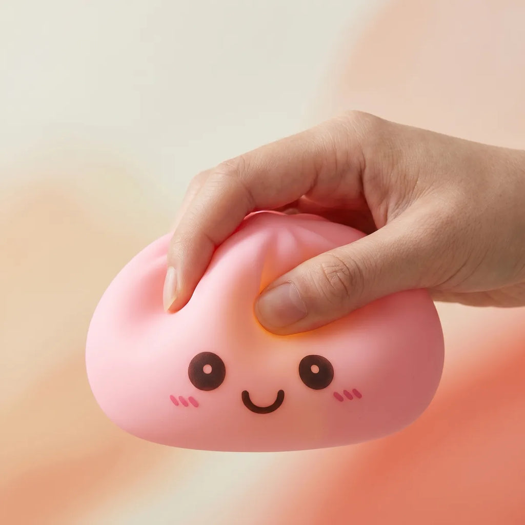 Pink squishy dumpling light being squeezed showing slow rising foam