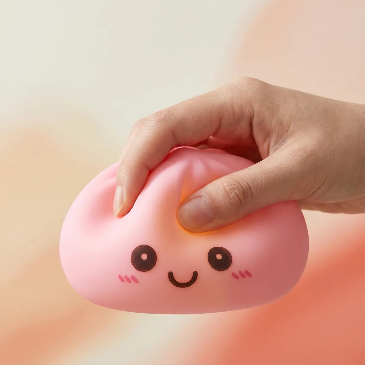Pink squishy dumpling light being squeezed showing slow rising foam