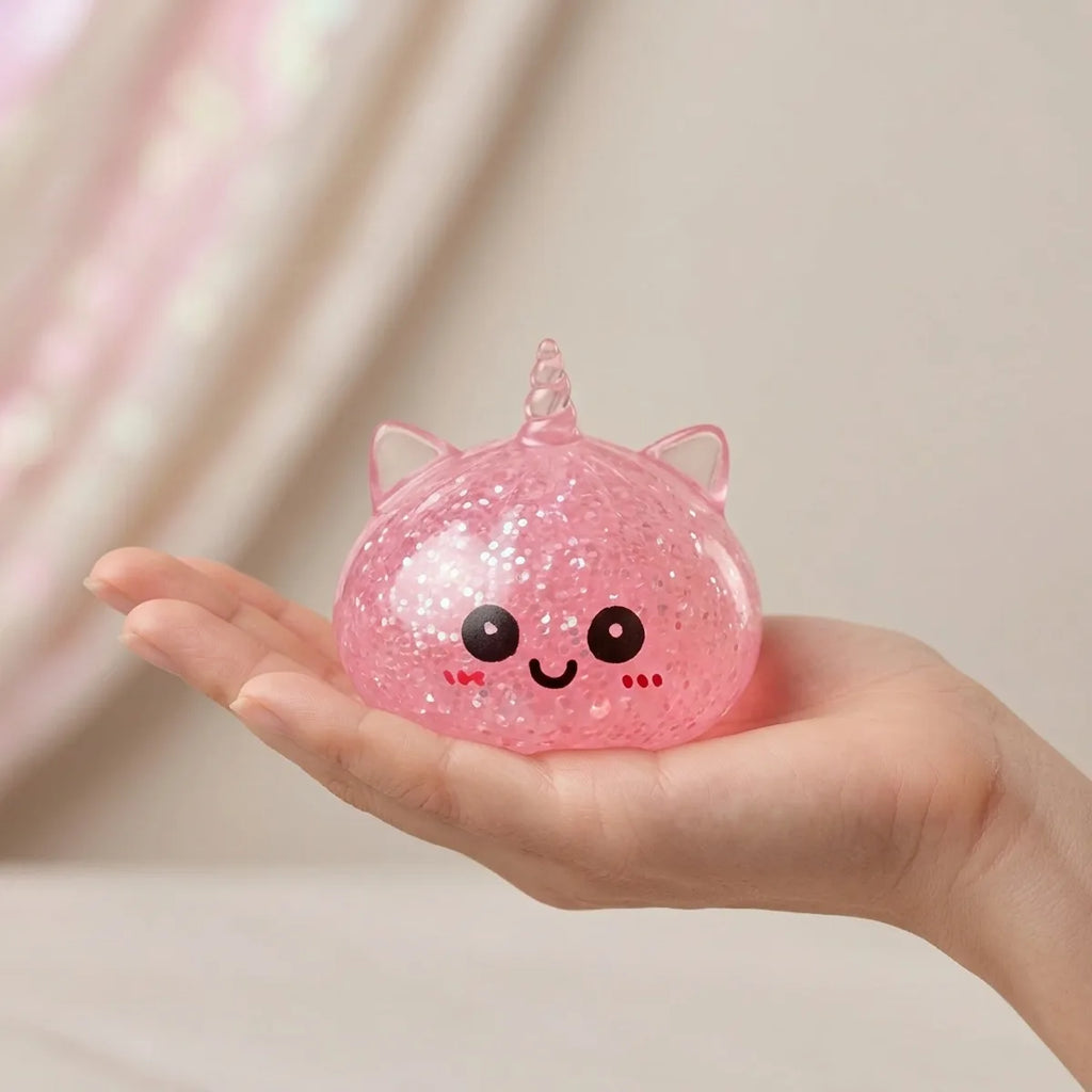 Hand holding the 5.5 cm pink unicorn glitter dumpling squishy to show its size