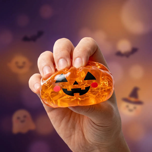 Pumpkin Halloween dumpling squishy squeezed flat to show its slow rising amber gel