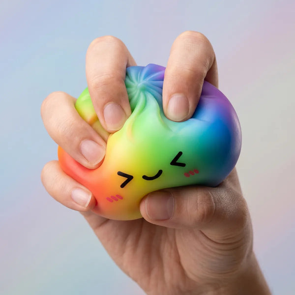 Rainbow color dumpling squishy being squeezed showing slow rising foam