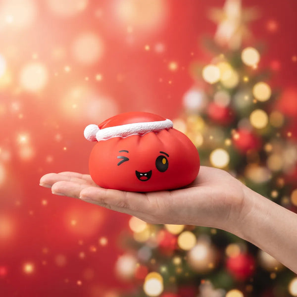 Cheeky Red Christmas Hat Dumpling Squishy resting on an open palm to show its real size