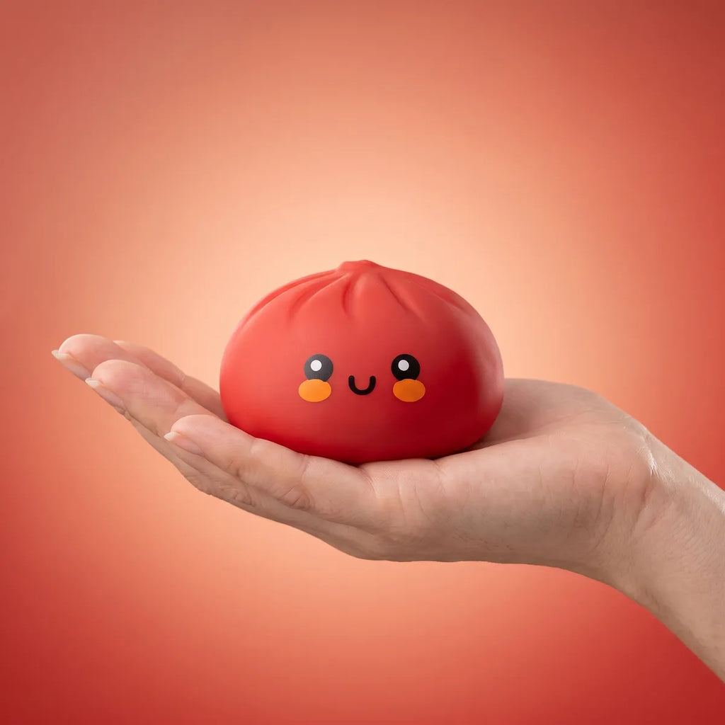 Hand squeezing a soft red dumpling squishy bun