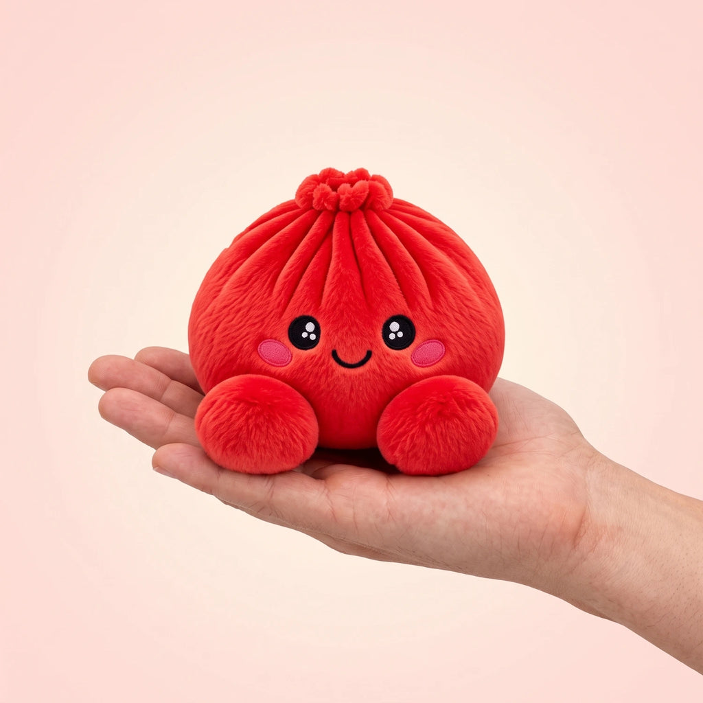 Ruby Red Dumpling Squishy Plush resting on an open palm to show its real size