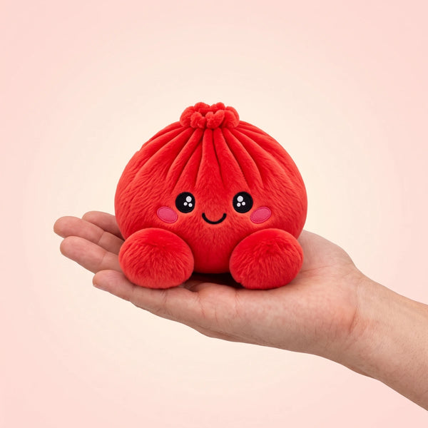 Ruby Red Dumpling Squishy Plush resting on an open palm to show its real size