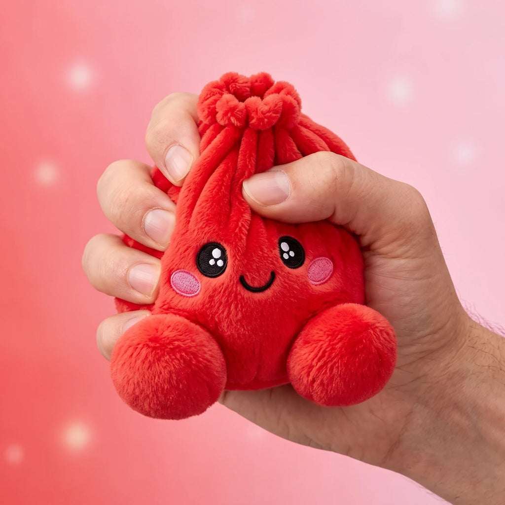 Hand gripping and squishing the Ruby Red Dumpling Squishy Plush