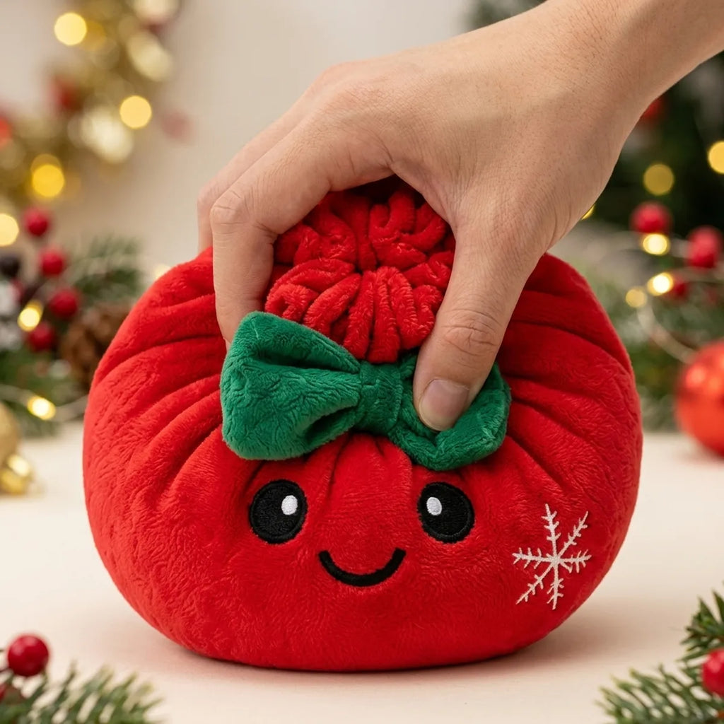 Hand pressing down on the soft Festive Ribbon Bow Dumpling Squishy Plush