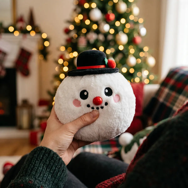 Person squeezing the Dapper Snow Hat Dumpling Squishy Plush as a fidget toy in a festive living room