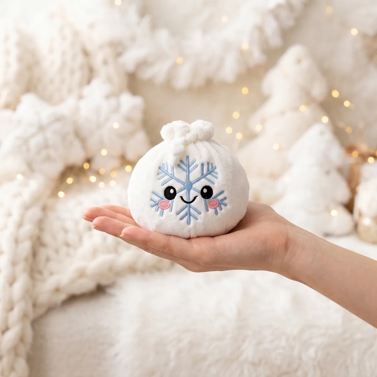 Winter Snowflake Dumpling Squishy Plush resting on an open palm to show its real size