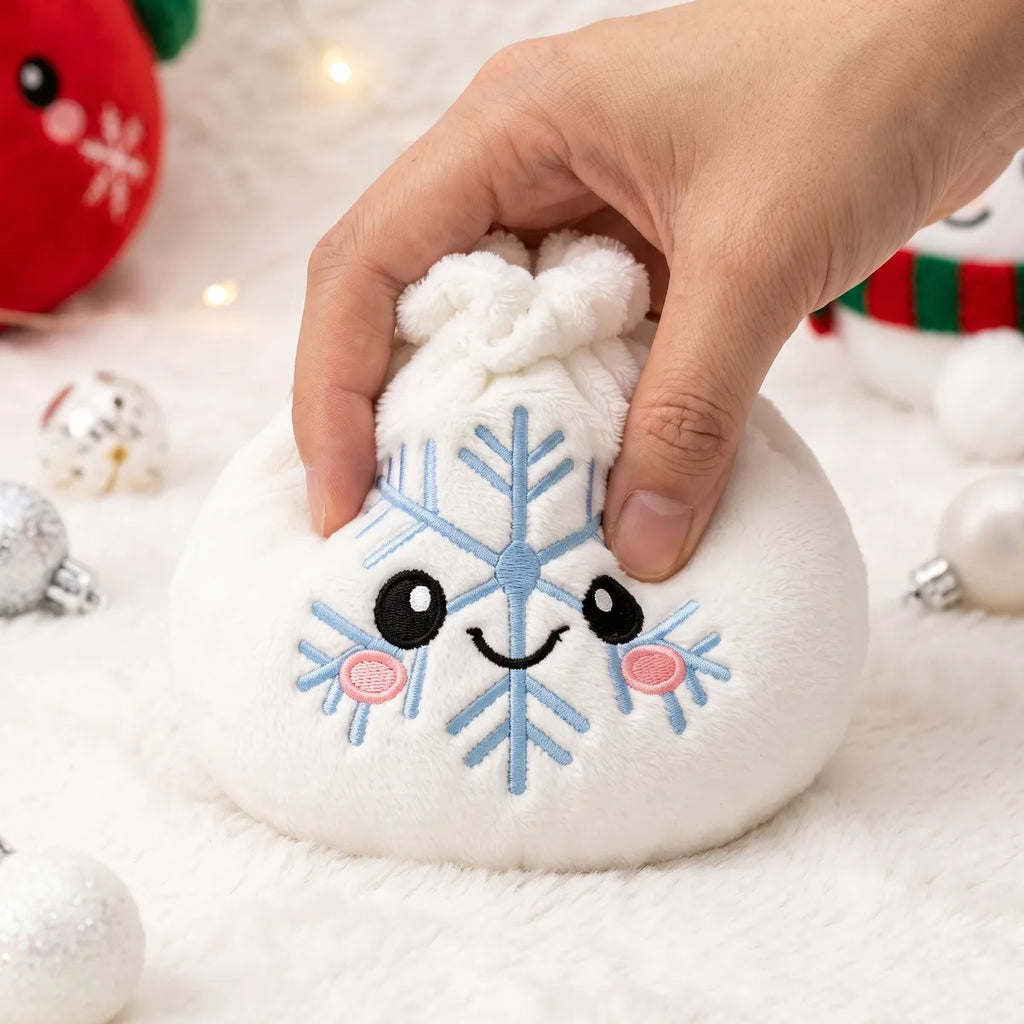 Hand pressing down on the soft Winter Snowflake Dumpling Squishy Plush