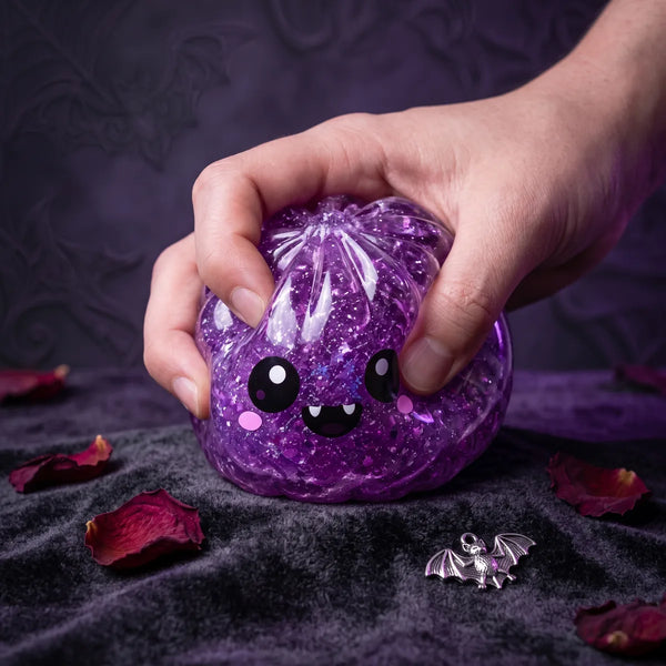 Action close up of the vampire Halloween dumpling squishy stretching under a two finger squeeze