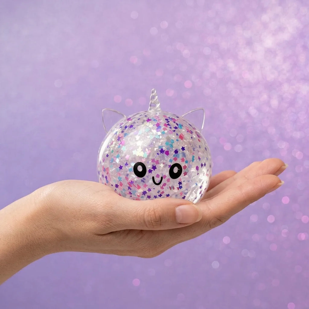 Hand holding the 8 cm white unicorn sparkle dumpling squishy to show its size