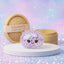 White unicorn sparkle dumpling squishy packed with pastel star confetti beside its bamboo steamer