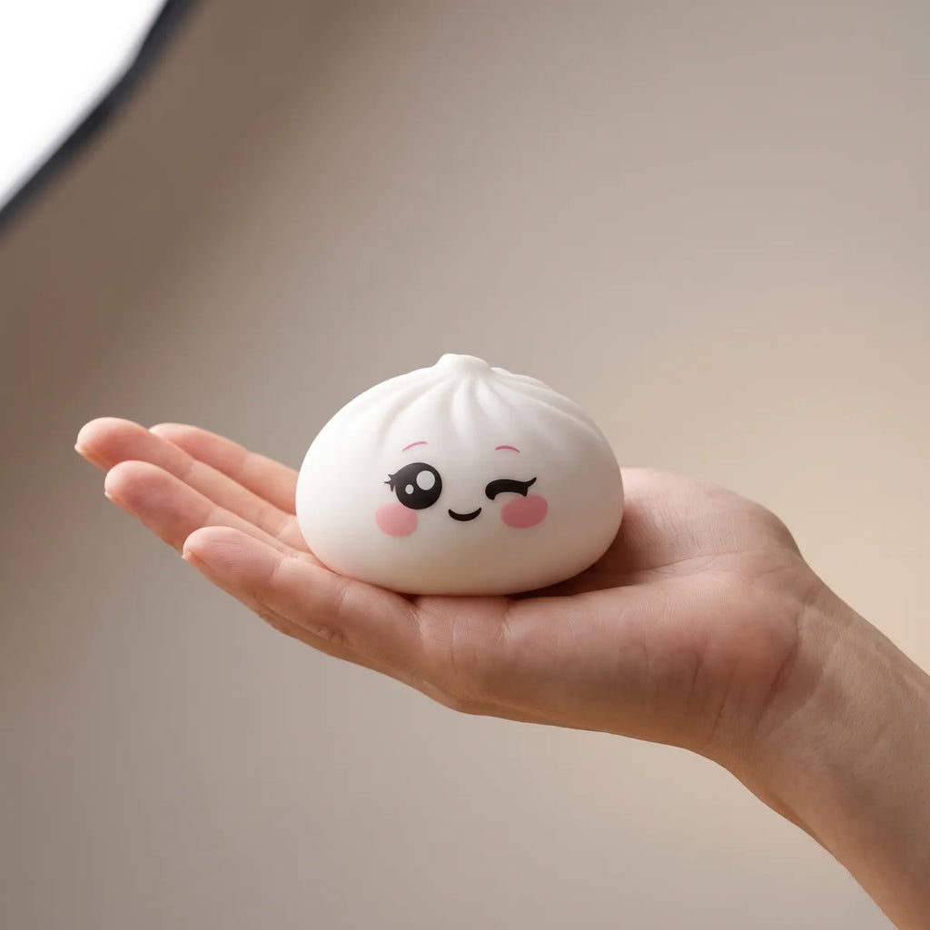Milky White Wink Dumpling Squishy resting on an open palm to show its real size