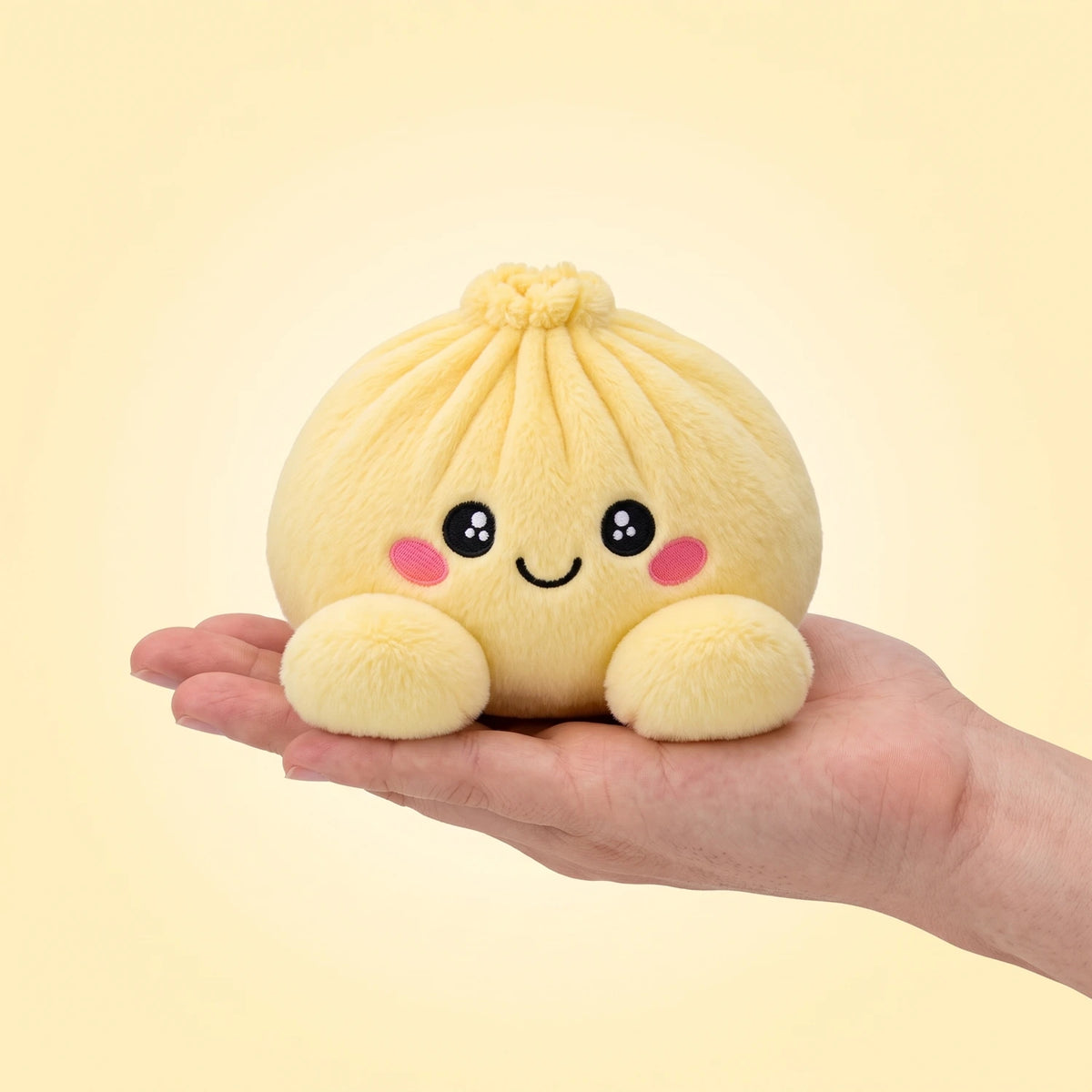 Lemon Yellow Dumpling Squishy Plush resting on an open palm to show its real size