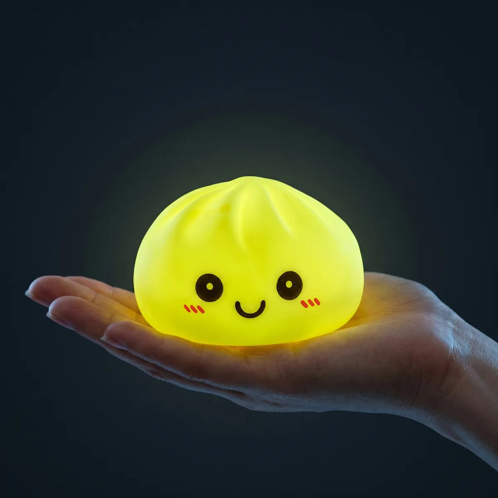 Yellow squishy dumpling light held in hand