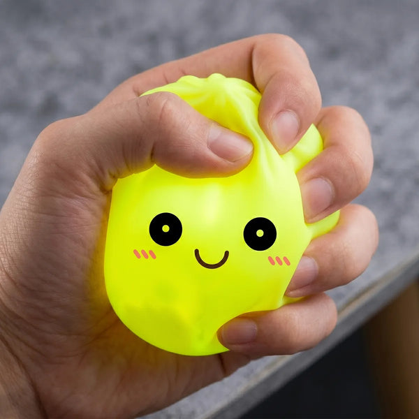 Hands playing with the yellow squishy dumpling light